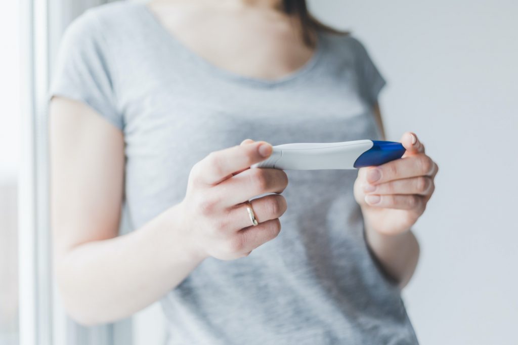 Woman looking and checking pregnancy test